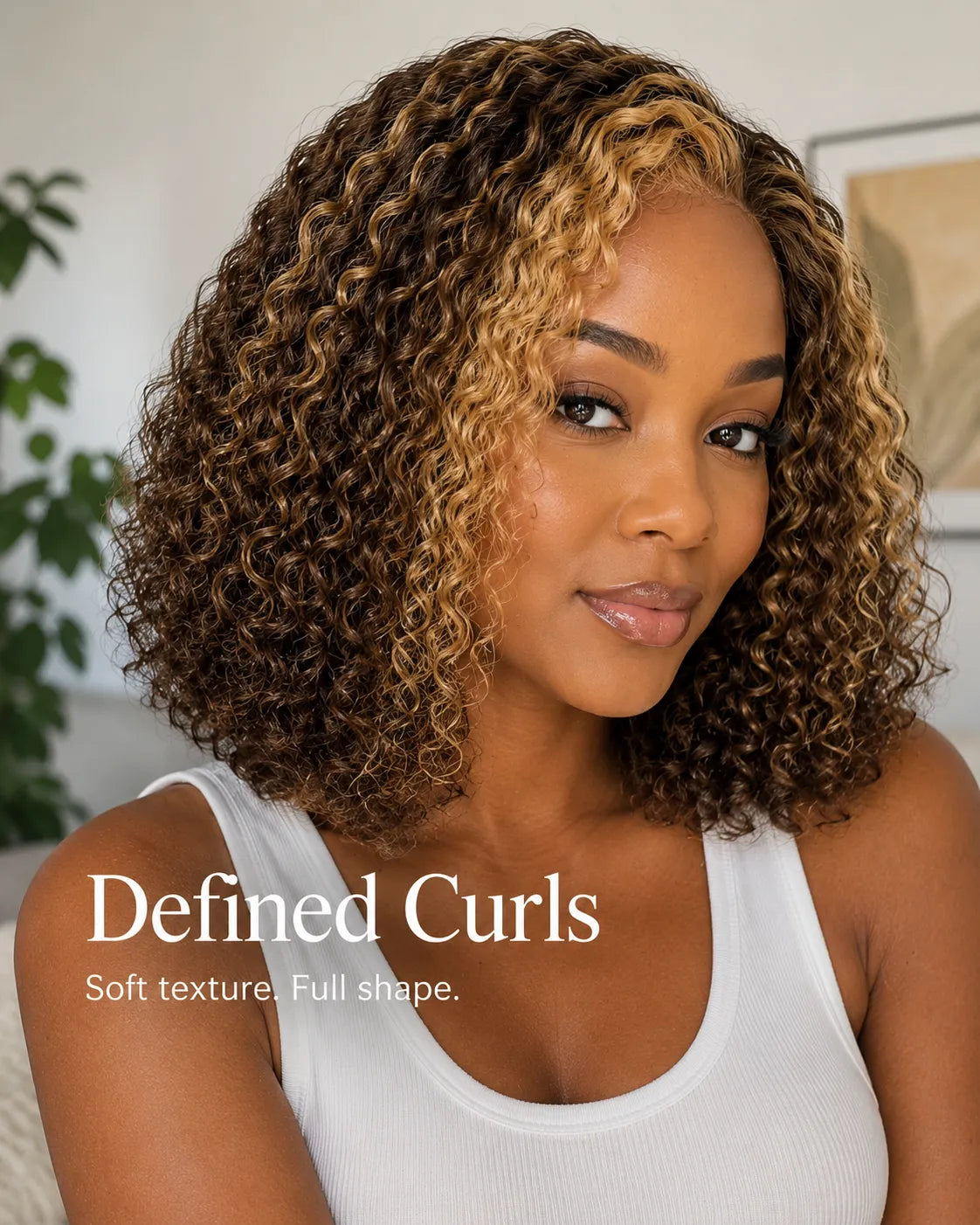 Lifestyle view of model wearing honey blonde curly human hair wig with soft texture and natural finish