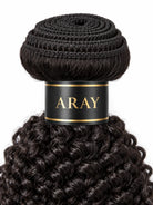 Lifestyle view of model wearing kinky curly human hair wig with soft texture and natural finish