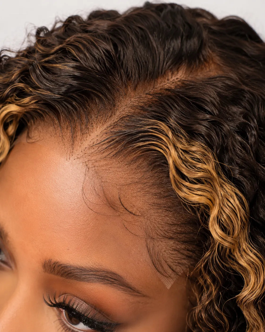 Close-up view of honey blonde kinky curly human hair wig texture and lace detail