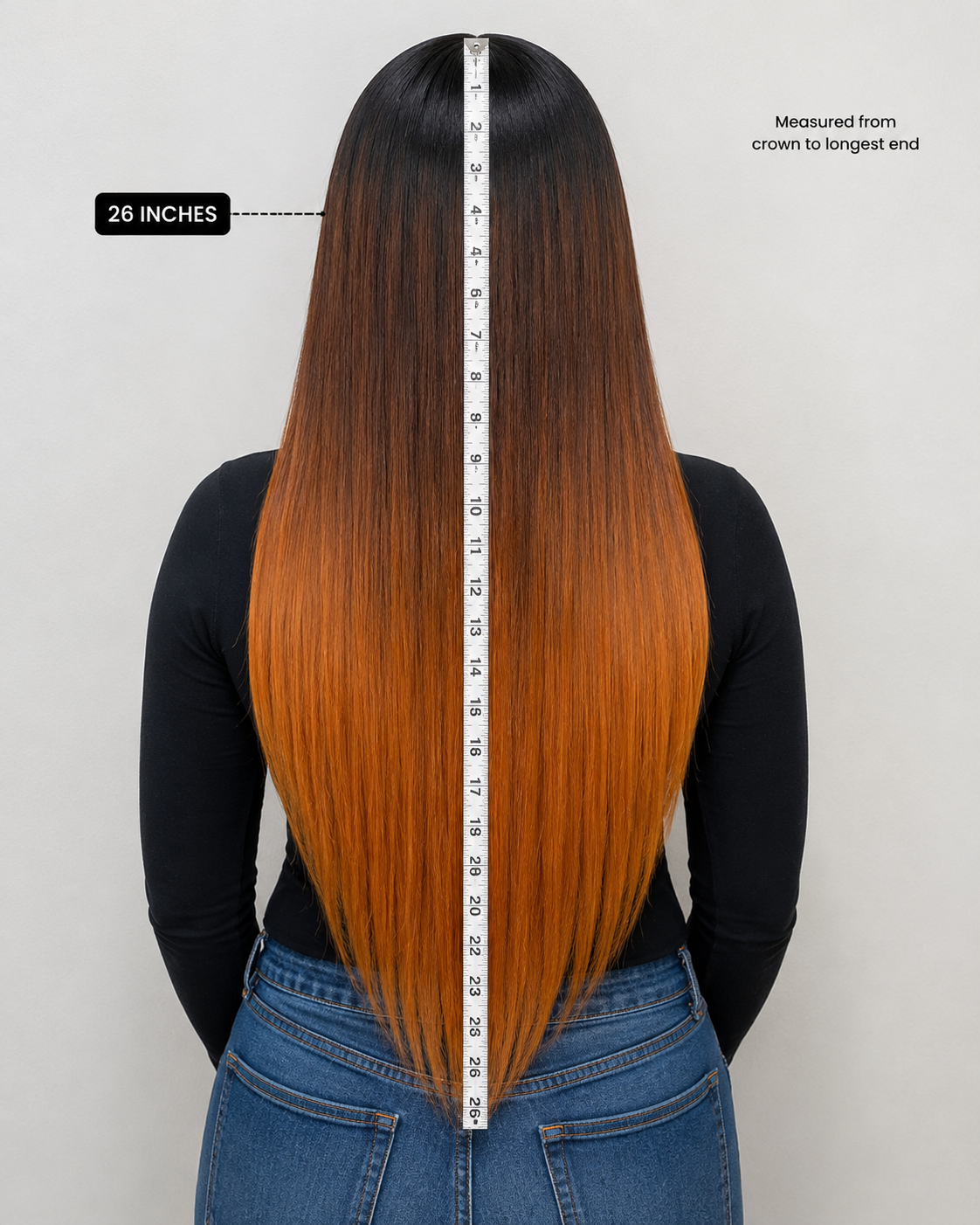 Person with long hair measured at 26 inches, wearing a black top and blue jeans on a white background.