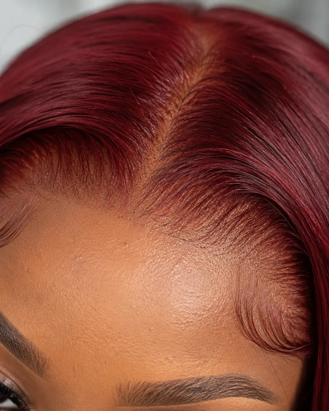 Close-up view of burgundy straight human hair wig texture and lace detail