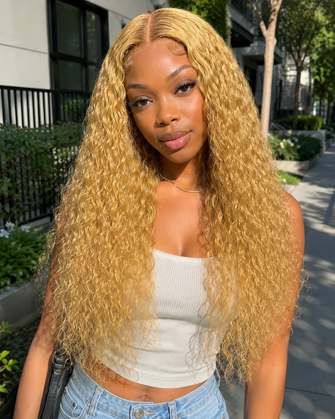 Front view of honey blonde water wave lace front human hair wig on model