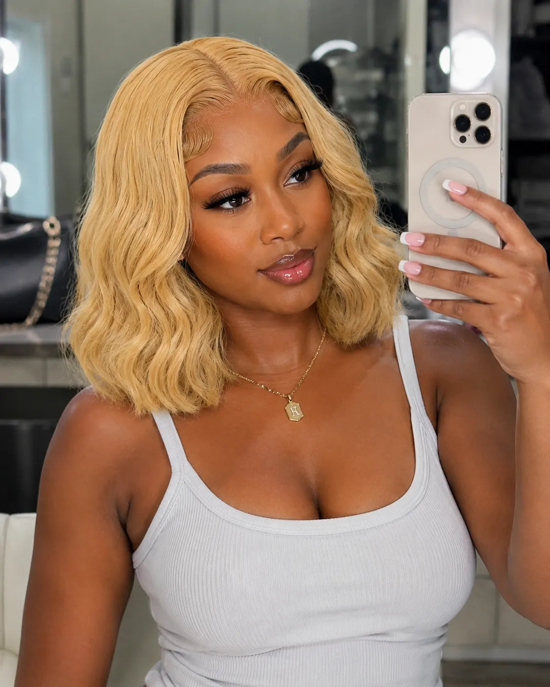 Front view of honey blonde body wave lace front human hair wig on model