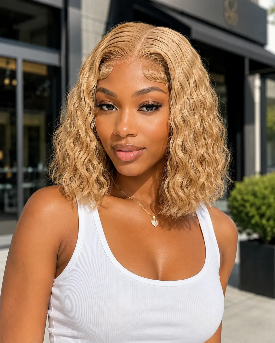 Front view of honey blonde water wave lace front human hair wig on model