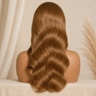 Mannequin head with long, wavy brown hair against a beige background
